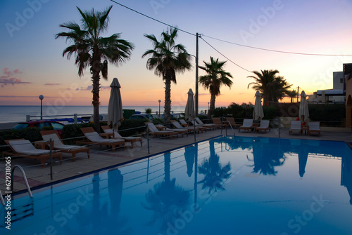 Pool outside. Swimming pool by the sea. Mediterranean Sea. Sunset. Cold evening lighting. Summer on the mediterranean sea. The water surface in the pool. The pool on the seashore.