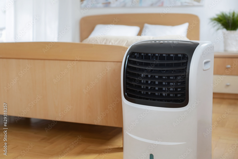 Portable mobile air conditioner stands in the bedroom at home, copy space