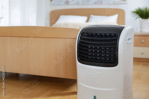 Obraz na płótnie Portable mobile air conditioner stands in the bedroom at home, copy space w salonie