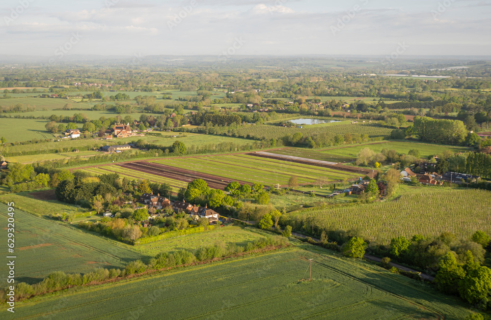 Aerial view of a farm and surrounding fields in the countryside in Kent, UK