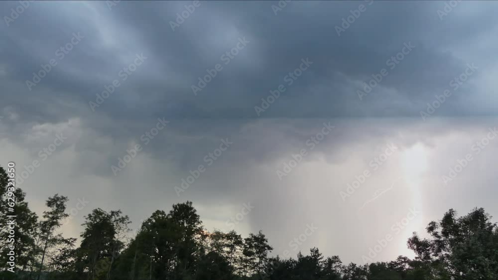 Thunderstorm with lightning, rainy clouds with an impending heavy rain, strong wind and horizon with green trees on summer season - timelapse with slow motion. Thunderstorm with lightning, rainy clouds with an impending heavy rain, strong wind and horizon with green trees on summer season - timelapse with slow motion.