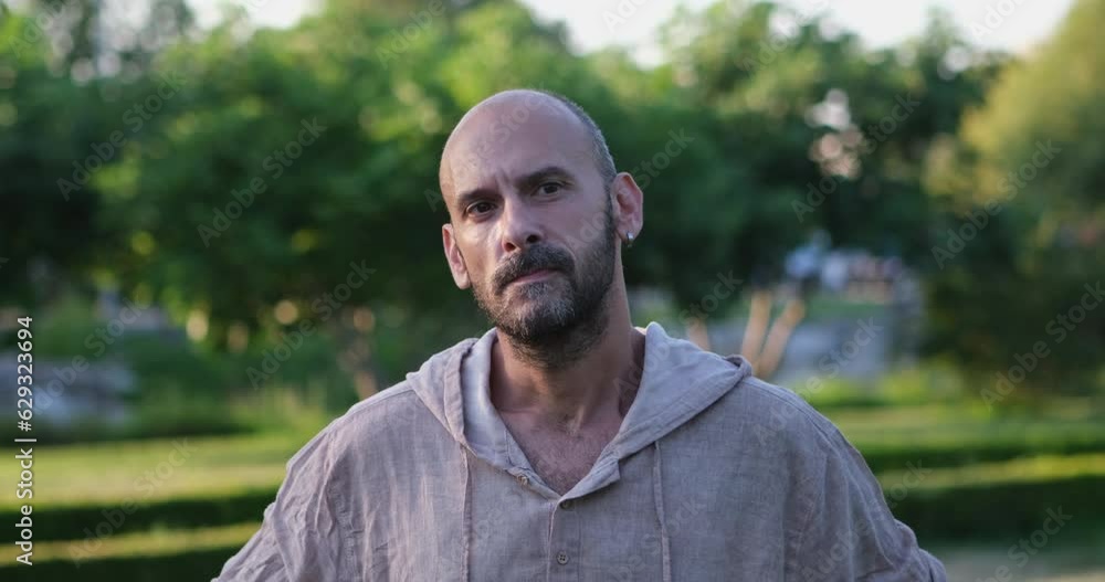 In the park, a man looks at the camera and makes facial expressions that clearly indicate he is experiencing deep disappointment and extreme sadness In the park, a man looks at the camera and makes facial expressions that clearly indicate he is experiencing deep disappointment and extreme sadness