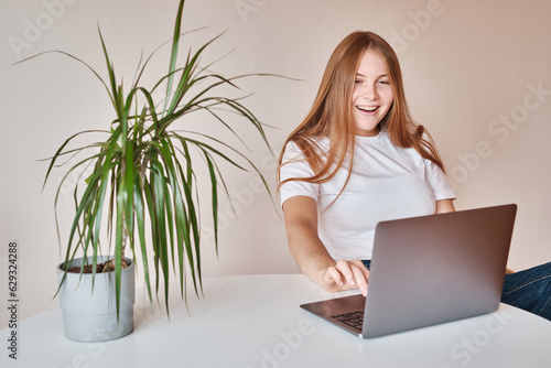 Woman works behind a laptop. Internet business. Freelance girl. Remote work. Modern lifestyle, working day. Mobile device. Type on the keyboard