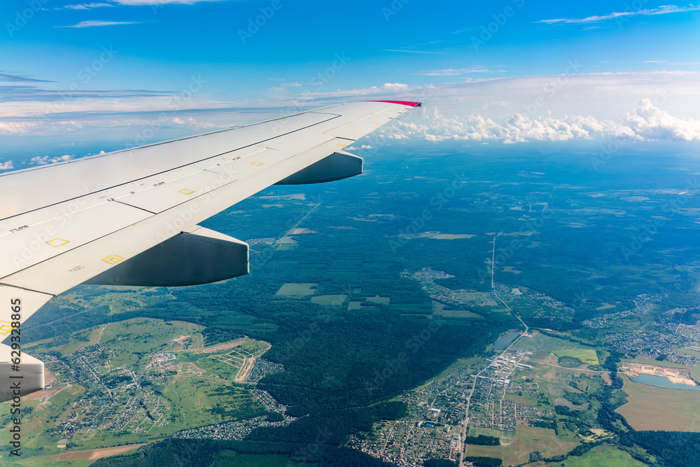 Obraz premium View from the airplane window at a beautiful cloudy sky and the airplane wing