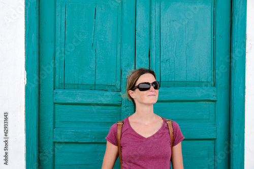 Content adult lady in sunglasses at shabby door