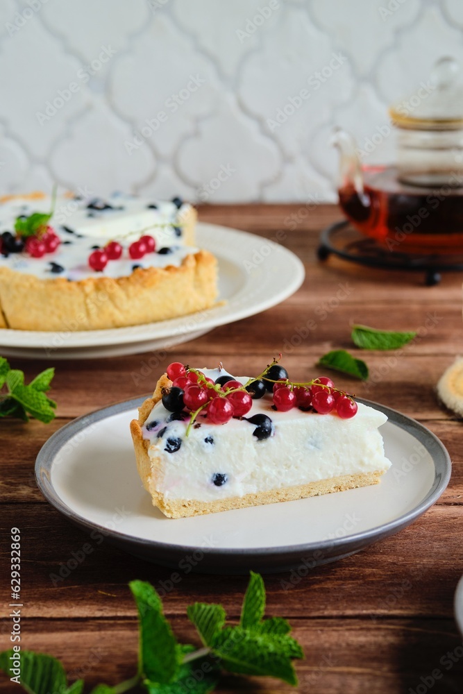 Dessert, sliced round cheesecake with blackcurrant on shortcrust pastry on a ceramic plate on a wooden background. Summer desserts, pastries with berries. Recipes dairy products. Dessert, sliced round cheesecake with blackcurrant on shortcrust pastry on a ceramic plate on a wooden background. Summer desserts, pastries with berries. Recipes dairy products.