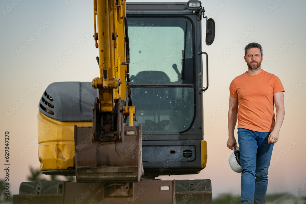 Builder with excavator for construction at the construction site. Machinery tractor with builder at buildings background. Excavator builder worker. Builder with helmet on construction site. Builder with excavator for construction at the construction site. Machinery tractor with builder at buildings background. Excavator builder worker. Builder with helmet on construction site.
