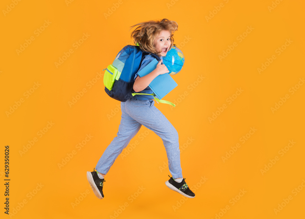 Full length of excited kid jumping. Funny excited school concept. Little student boy with backpack go to study, jumping. Schoolchild, pupil jump on yellow isolated background. Full length of excited kid jumping. Funny excited school concept. Little student boy with backpack go to study, jumping. Schoolchild, pupil jump on yellow isolated background.
