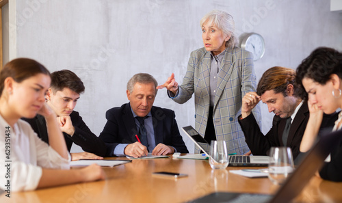 Elderly female boss expresses dissatisfaction with the work of the top managers team