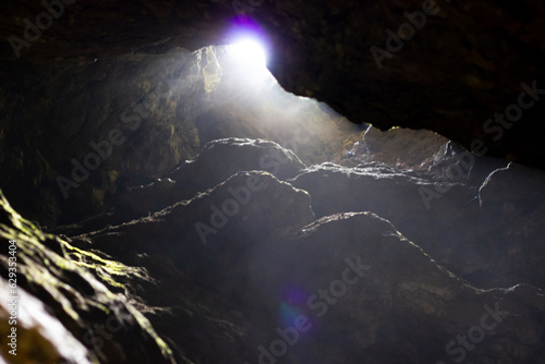 View outside from the depths of the cave, South Urals, Bashkiria. A haze of blackness. July, coolness from the dungeon