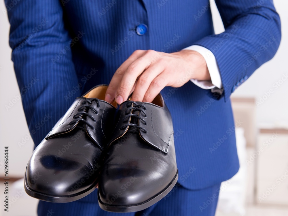 Fototapeta premium Young handsome businessman choosing shoes at home