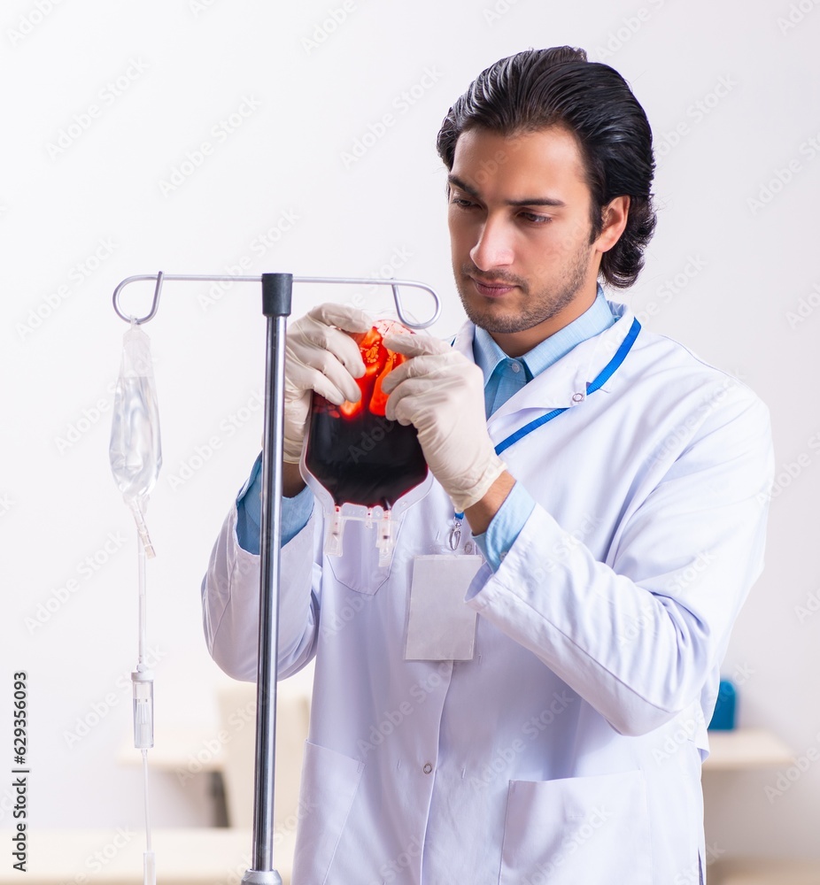 Young male doctor in blood transfusion concept Young male doctor in blood transfusion concept