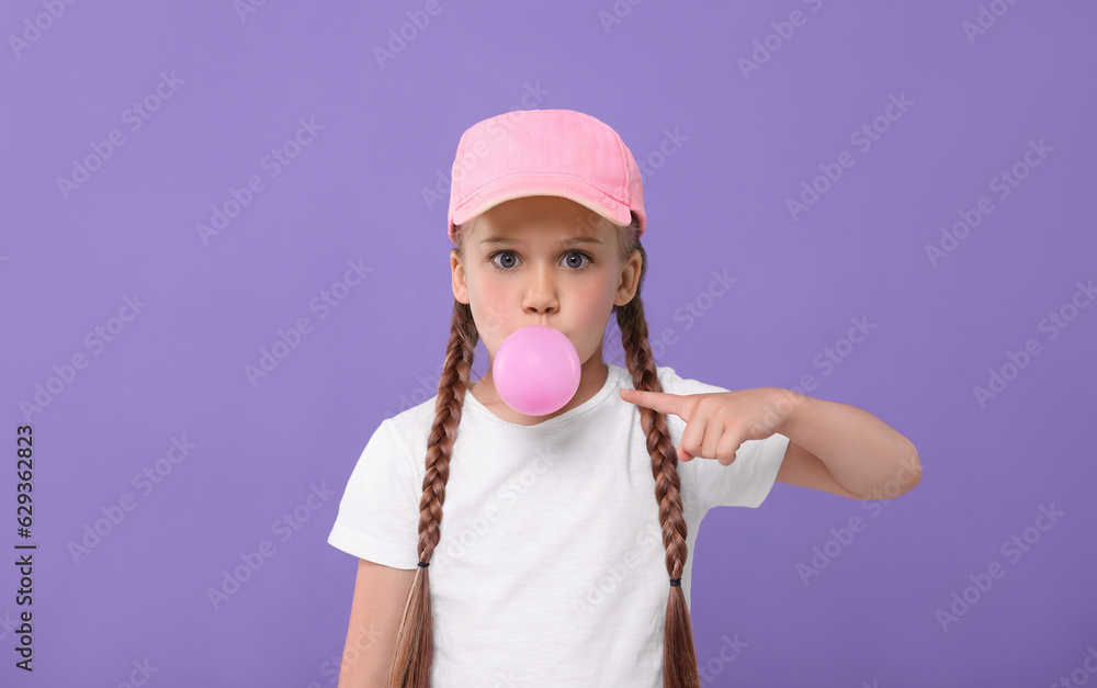 Surprised girl blowing bubble gum on purple background Surprised girl blowing bubble gum on purple background