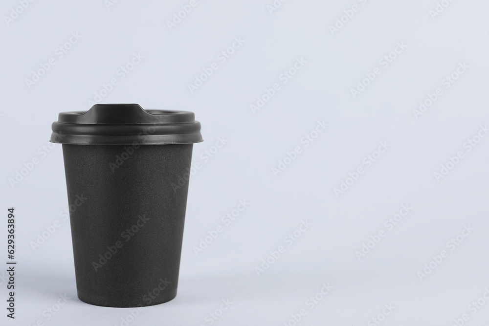 Black paper cup with plastic lid on light background, space for text. Coffee to go Black paper cup with plastic lid on light background, space for text. Coffee to go