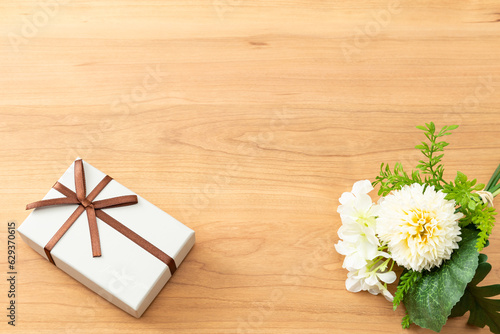 木目背景に花束とプレゼントボックス