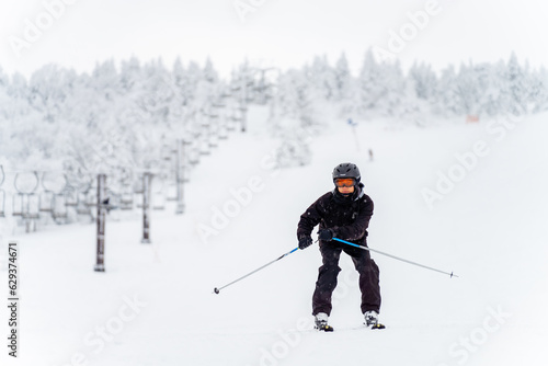Young Asian man athlete practice downhill sliding skiing on snow mountain at ski resort. Handsome guy enjoy outdoor active lifestyle travel nature and winter extreme sport training on holiday vacation