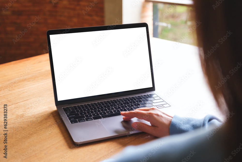 Mockup image of a woman using and touching on laptop computer touchpad with blank white desktop screen Mockup image of a woman using and touching on laptop computer touchpad with blank white desktop screen