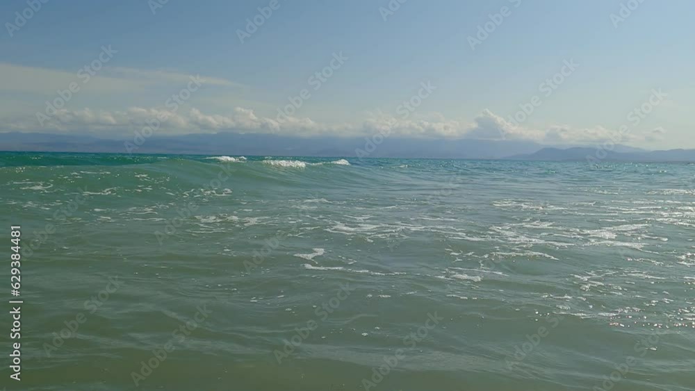 Beautiful waves with foam of blue Issyk-Kul Lake (second biggest mountain lake in the world) in Kyrgyzstan in an summer sunny day. Touristic area of this Central Asia country Beautiful waves with foam of blue Issyk-Kul Lake (second biggest mountain lake in the world) in Kyrgyzstan in an summer sunny day. Touristic area of this Central Asia country