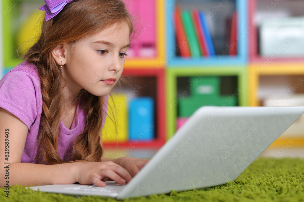 cute girl using laptop lies on the carpet cute girl using laptop lies on the carpet