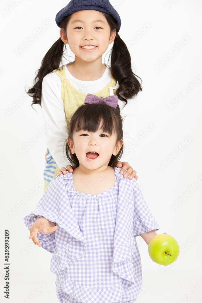 帽子を被った女の子とリンゴを持つ赤ちゃん 帽子を被った女の子とリンゴを持つ赤ちゃん
