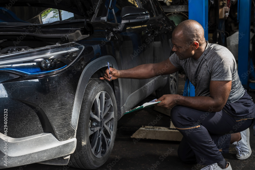 Black car mechanic man working in auto repair shop Black car mechanic man working in auto repair shop