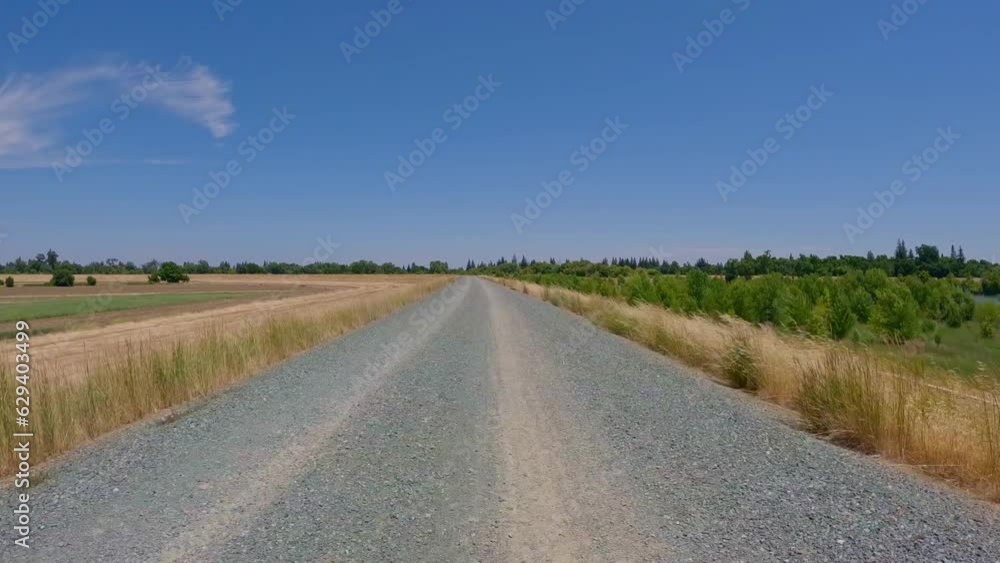Riding on a rocky levee road in california in summer Riding on a rocky levee road in california in summer