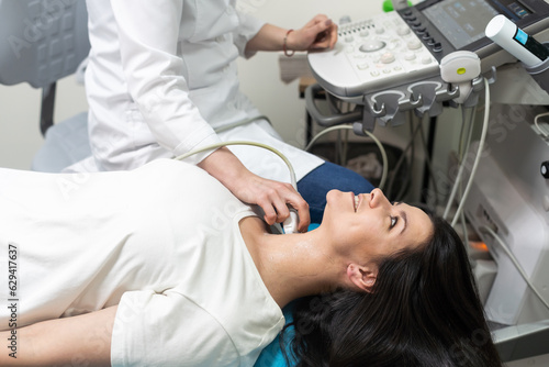 Woman endocrinologist making ultrasonography to a female patient in an ultrasound office. Ultrasound diagnostics