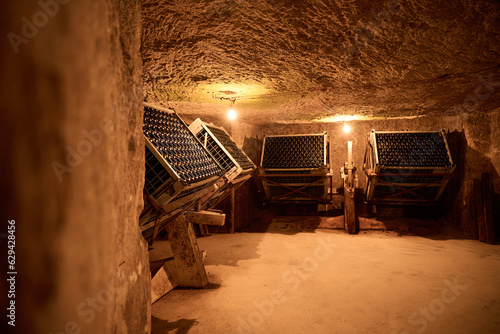 Wine bottles aging in caves in France at Monmousseau winery