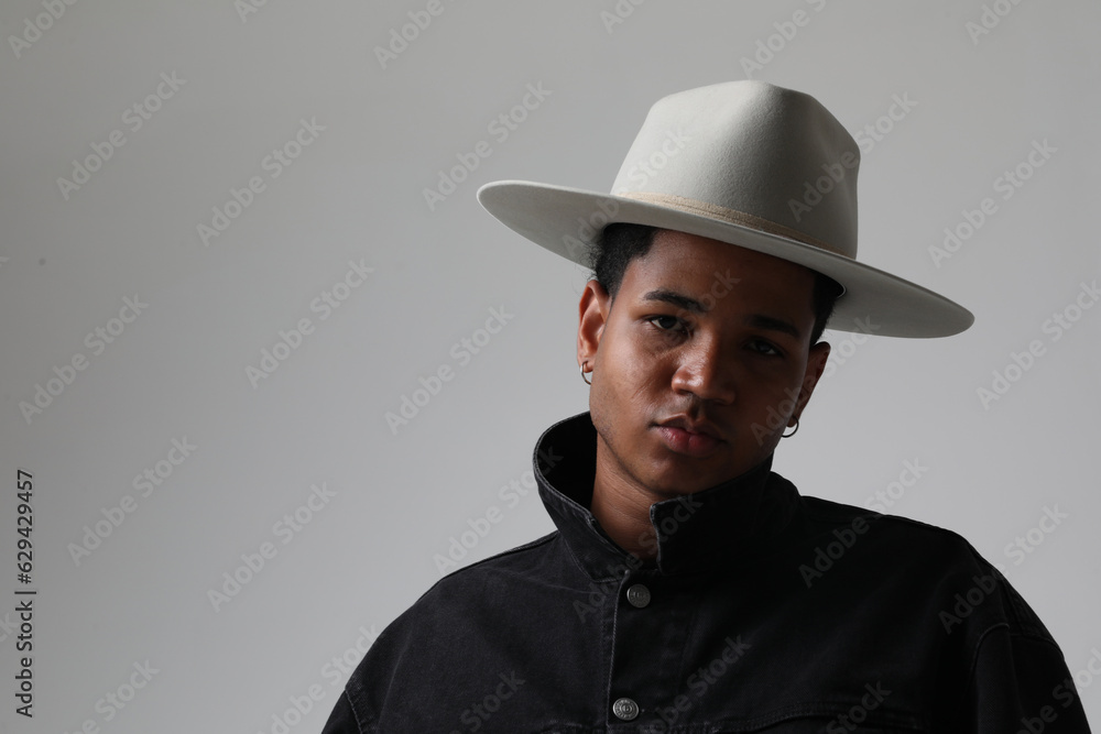 Portrait of handsome dark-skinned young man wearing trendy hat. Isolated. Portrait of handsome dark-skinned young man wearing trendy hat. Isolated.