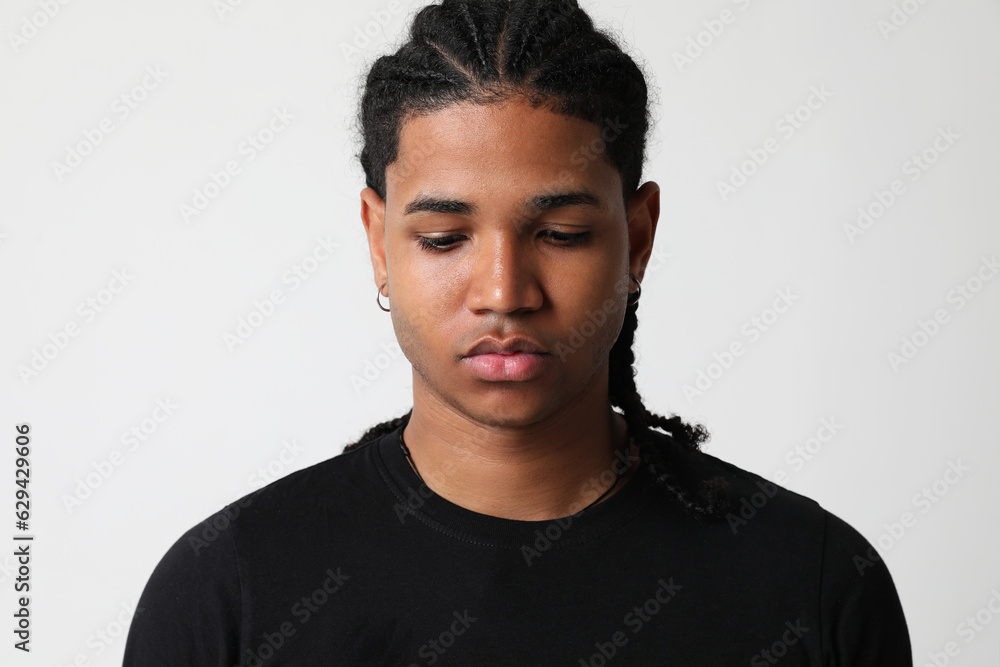 Dark-skinned young man posing in the studio and looking down. Mind set concept. Dark-skinned young man posing in the studio and looking down. Mind set concept.