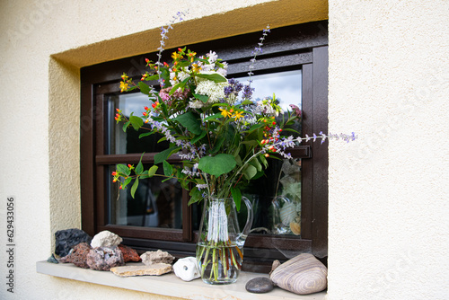 Außendekoration - Ein schöner Strauß mit Sommerblumen in einem Fenster