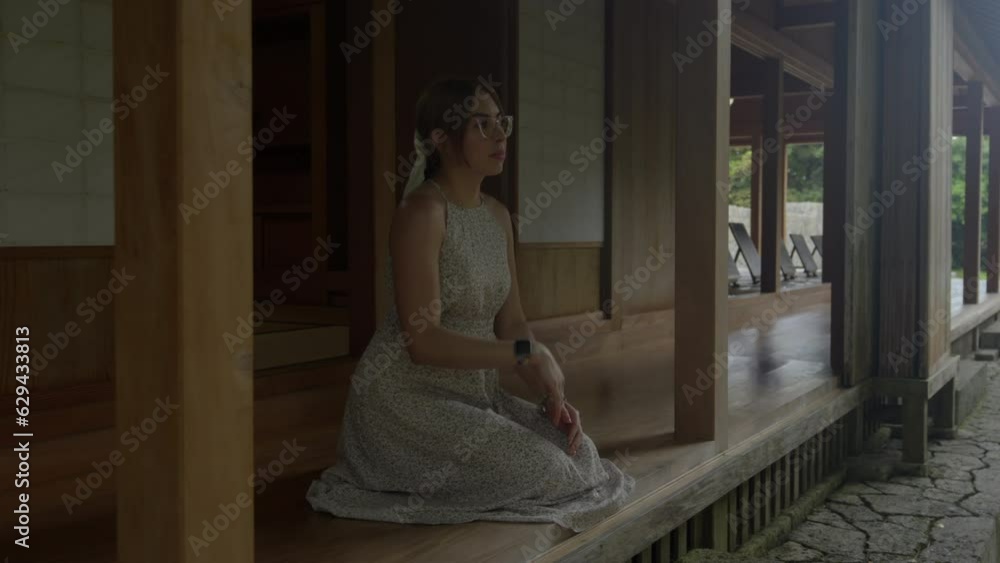 Peaceful female model woman with glasses smile in traditional japanese house garden at okinawa japan at Tamaudun mausoleum Peaceful female model woman with glasses smile in traditional japanese house garden at okinawa japan at Tamaudun mausoleum
