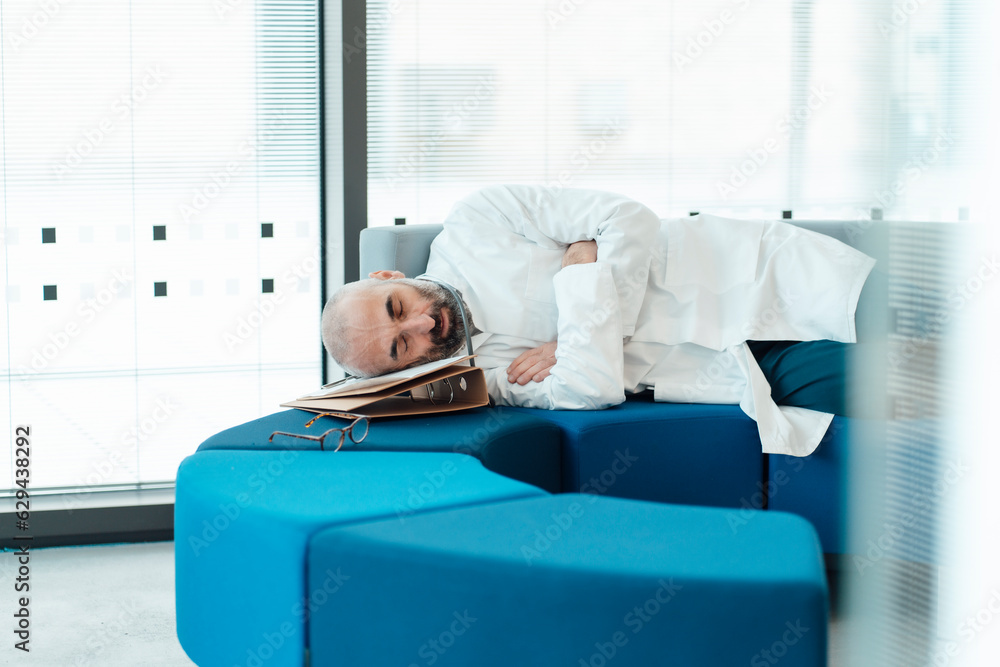 Tired doctor sleeping on sofa in hospital