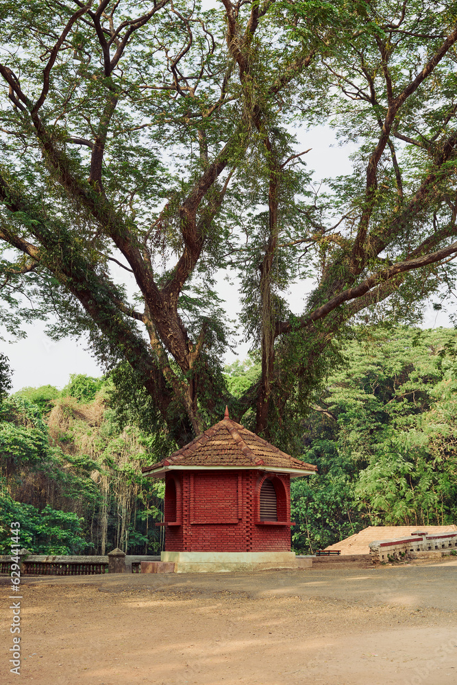 A red brick booth with tiled roof under a big tree A red brick booth with tiled roof under a big tree