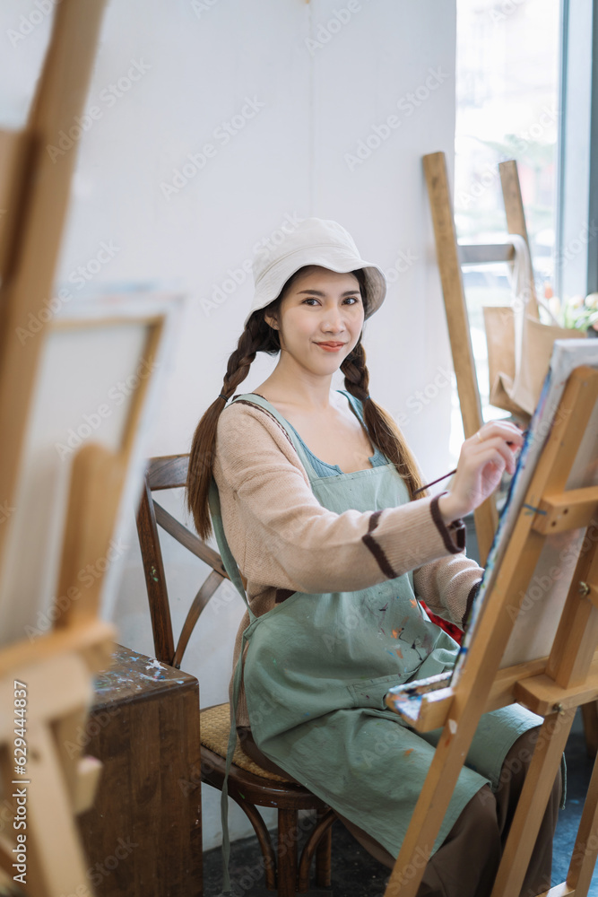 Young female artist painting on canvas in the home studio, fine arts and creativity concept. Young female artist painting on canvas in the home studio, fine arts and creativity concept.