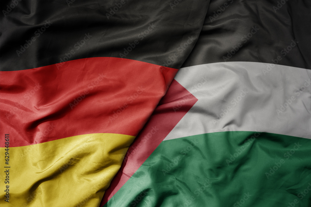 big waving realistic national colorful flag of germany and national flag of palestine .