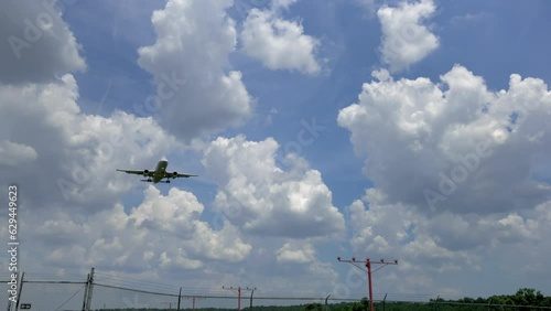 Camera Following Airplane Low Overhead on Approach to Landing at Airport photo