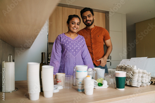 Young indian couple garbage picking for recycling at home photo