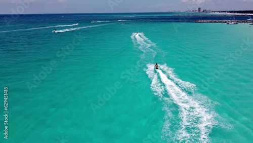 Aerial shot of crystal clear waters of Shell Island next to St. Andrews Florida State Park near panama city beach. Unidentified person driving jet ski and having adventure fun in clear blue water photo