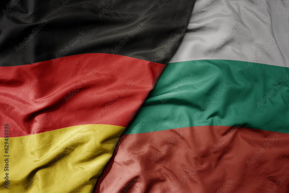 big waving realistic national colorful flag of germany and national flag of bulgaria .