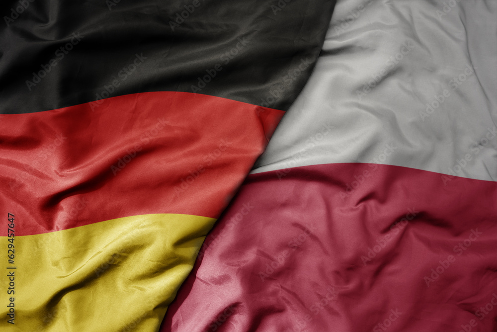 big waving realistic national colorful flag of germany and national flag of poland .