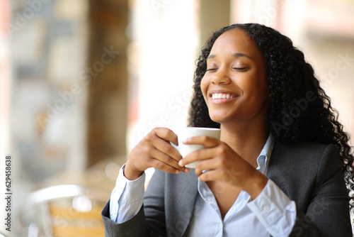 Happy black executive breathing in a coffee shop