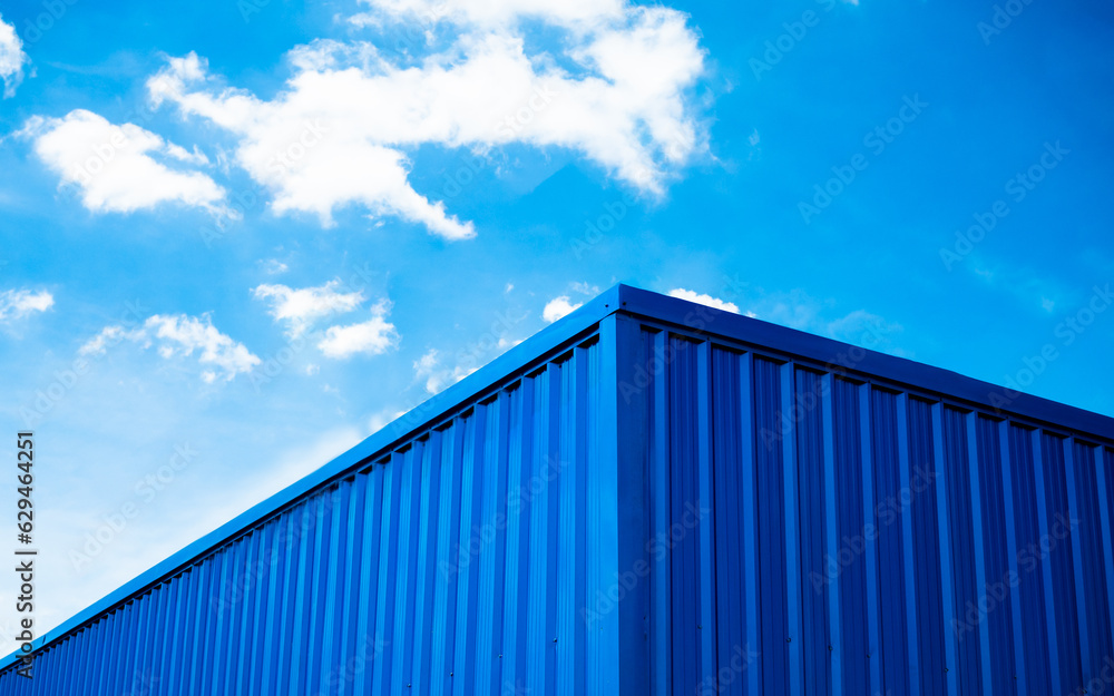 Blue warehouse roof with sky and clouds background Blue warehouse roof with sky and clouds background