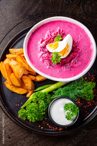 Vegetable cold soup with beet, cucumber, radsih and egg on wooden table photo