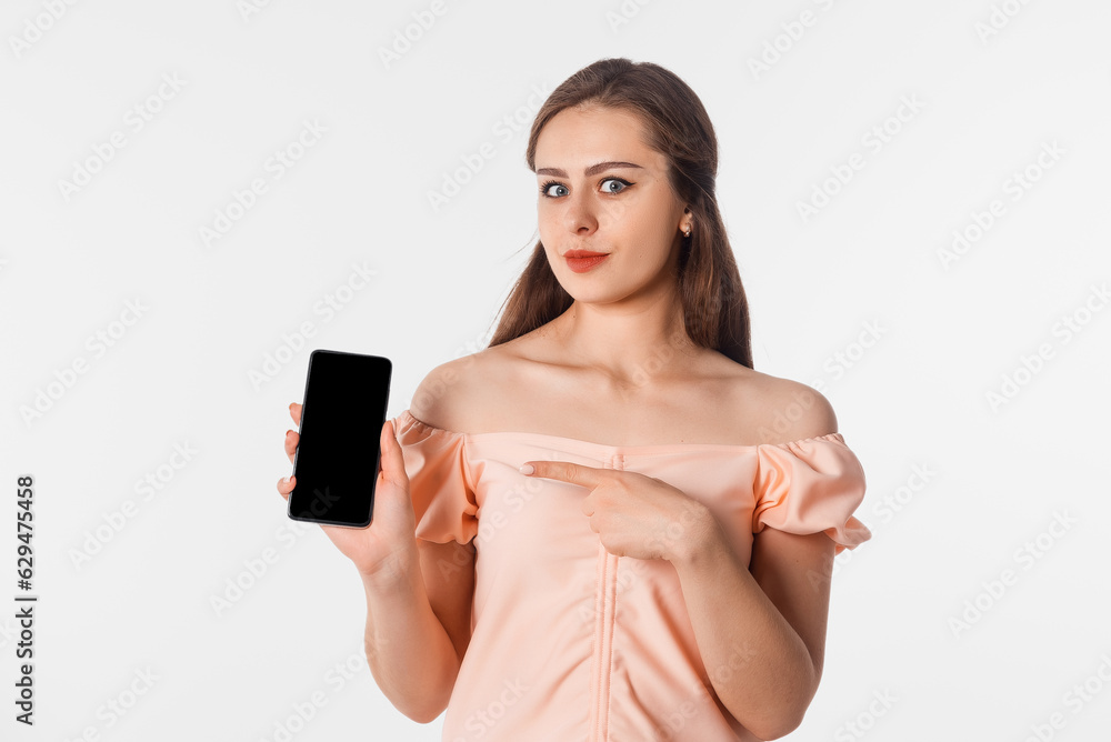 Young woman show empty smartphone screen with positive expression, stands against neutral studio background. Mobile phone with black screen in female hand. Young woman show empty smartphone screen with positive expression, stands against neutral studio background. Mobile phone with black screen in female hand.