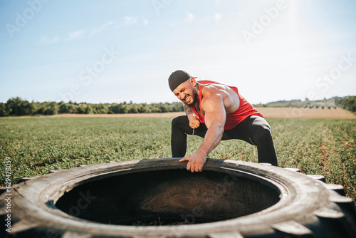 An inspiring image features a muscular male athlete practicing wheel pulls, exemplifying physical fitness and determination. Cross Fit Enthusiast Mastering Wheel Pull Training Outside