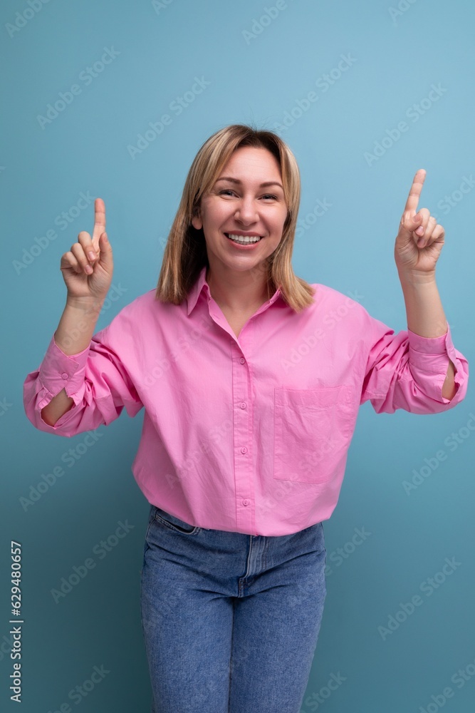 young successful blond careerist leader woman in a pink blouse shows her hands towards the empty space for advertising young successful blond careerist leader woman in a pink blouse shows her hands towards the empty space for advertising
