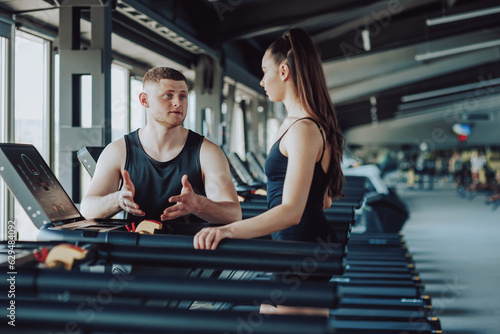 encapsulates the essence of effective training, with a male personal trainer providing guidance and explaining exercise techniques to a woman, creating a positive and educational fitness experience.