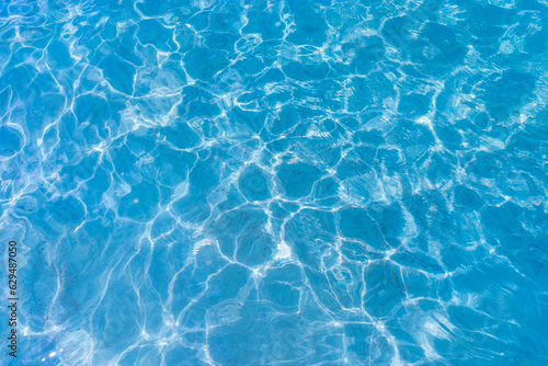 Clear blue ripple sea water surface. Pure sparkled transparent liquid natural texture background with sunlight reflections
