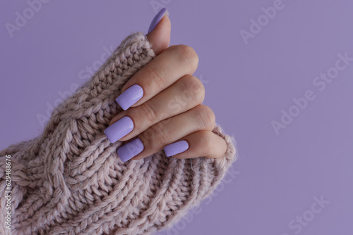 Fingernails of purple color. Gelish manicure. Female's hand with delicate nails of trendy lavender color photo